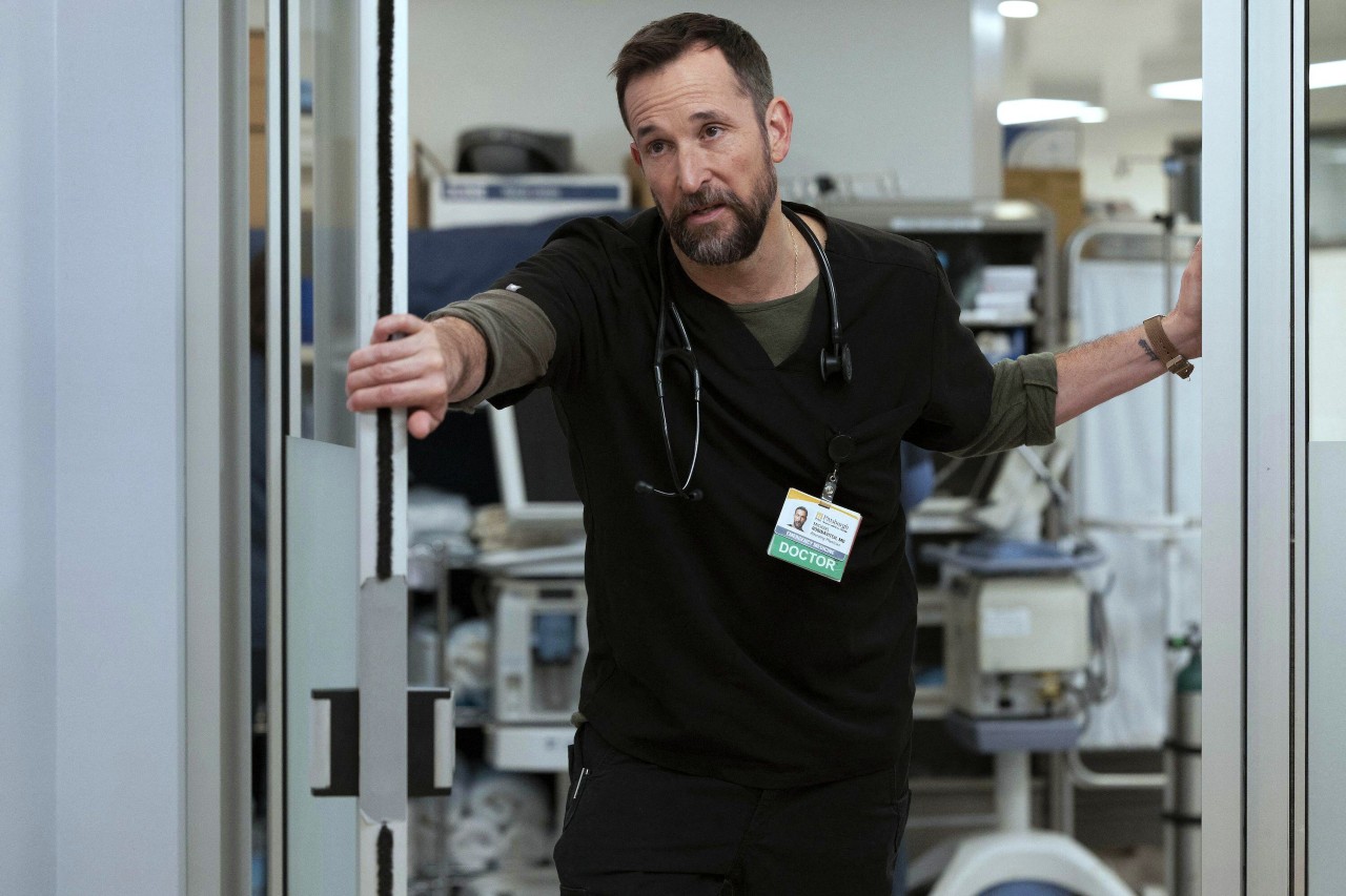 Actor Noah Wyle plays Dr. Michael "Robby" Robinovitch on the hit TV series The Pitt. He is in his scrubs in the ER.
