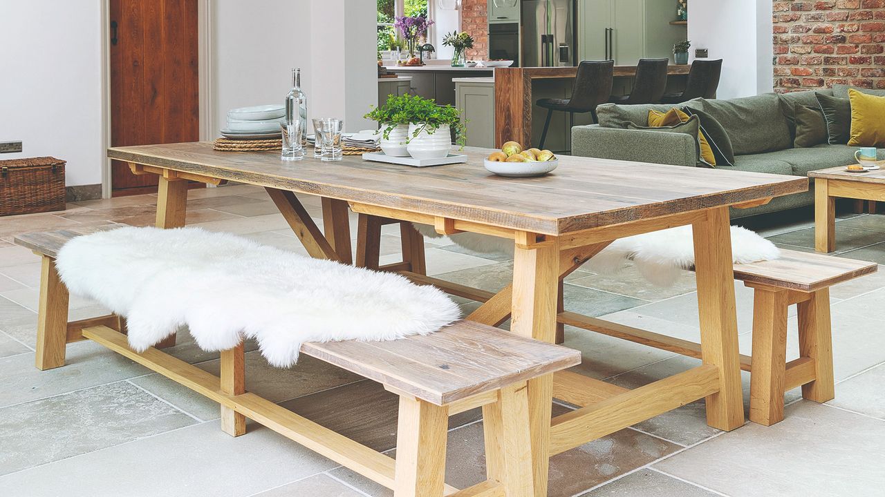 A large open-plan dining room with a long rectangular wooden dining table and matching dining benches