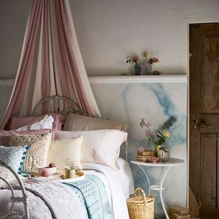 bedroom with white and blue designed wall wooden door bed with cushion and curtain