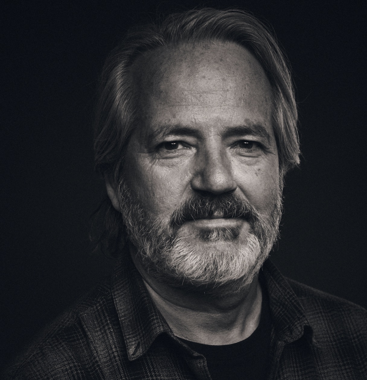 A black-and-white portrait of a bearded man