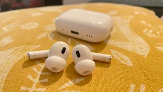 Apple AirPods Pro 2 with USB-C case on a yellow cushion