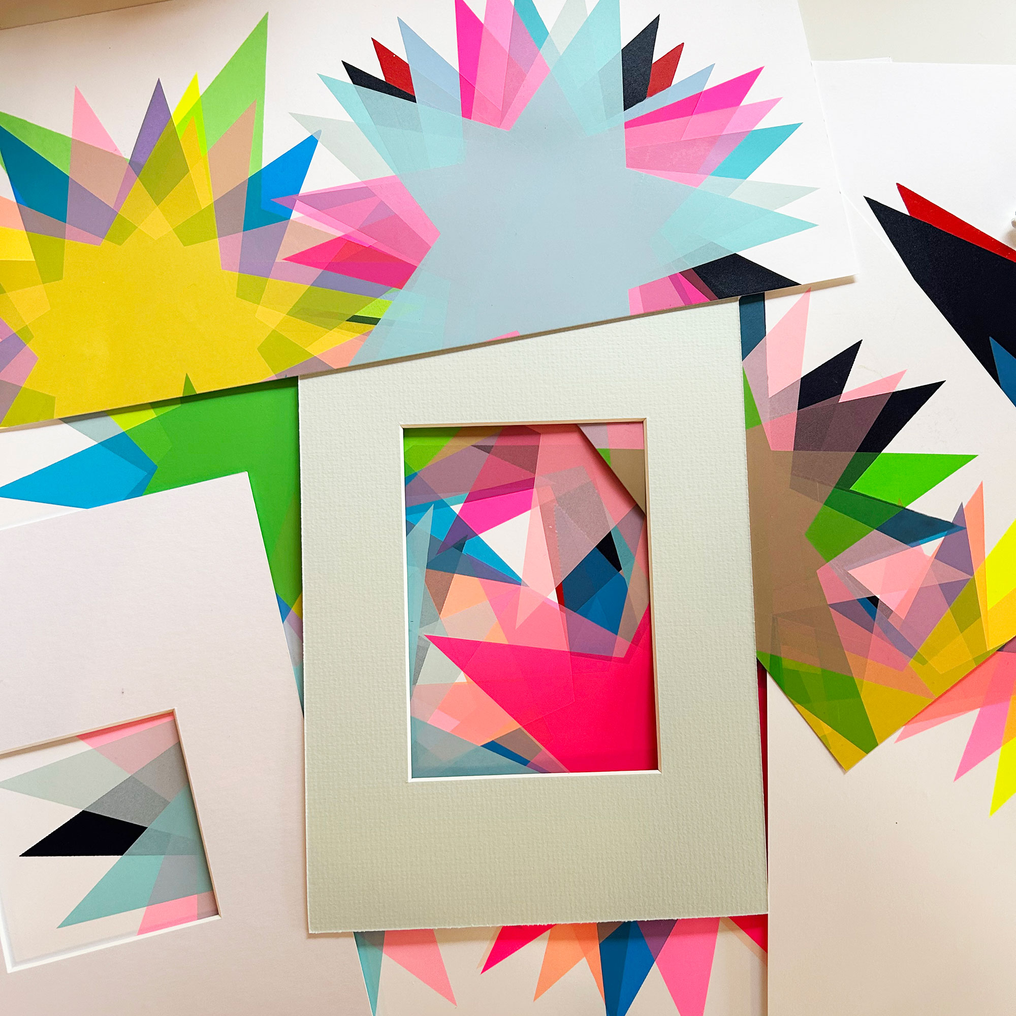 Collection of screenprints of multicoloured stars laid on top of one another beneath framing mount