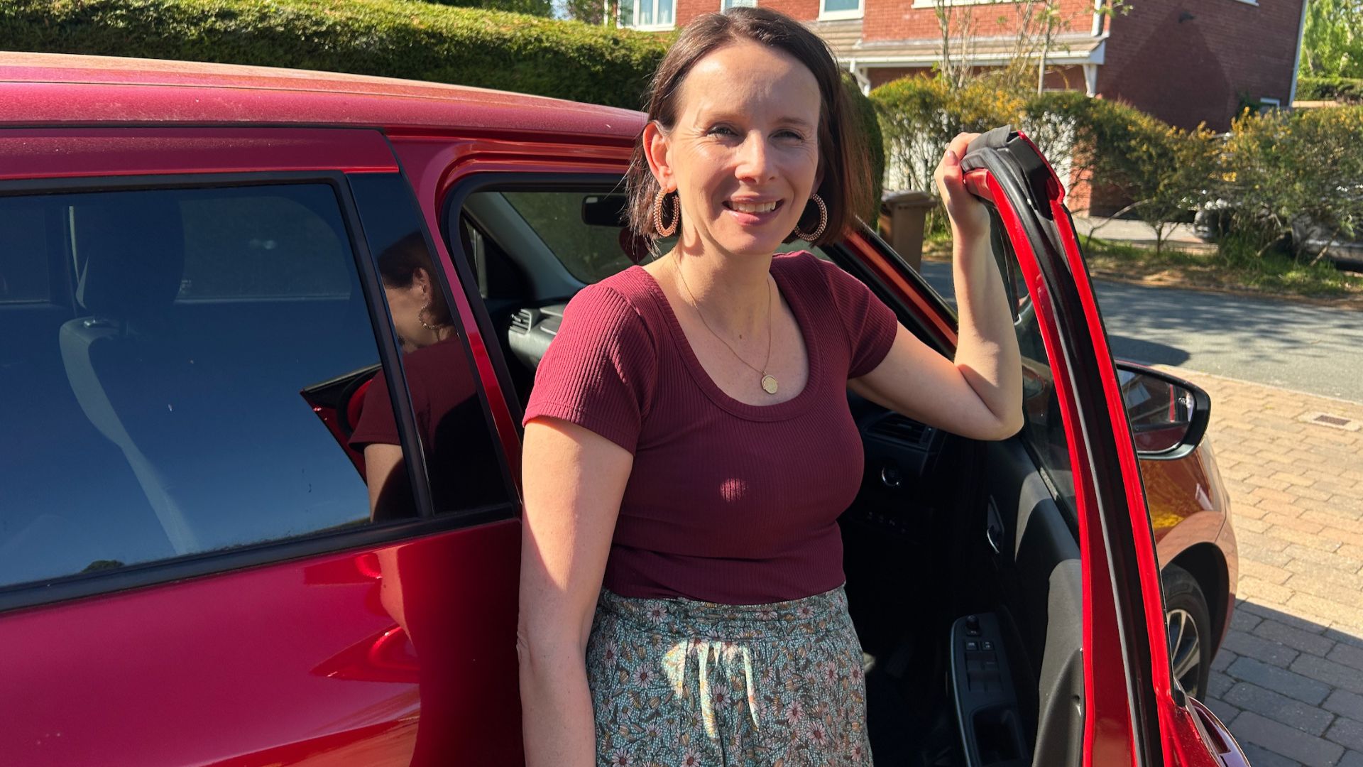Michelle Rowley with her car, smiling