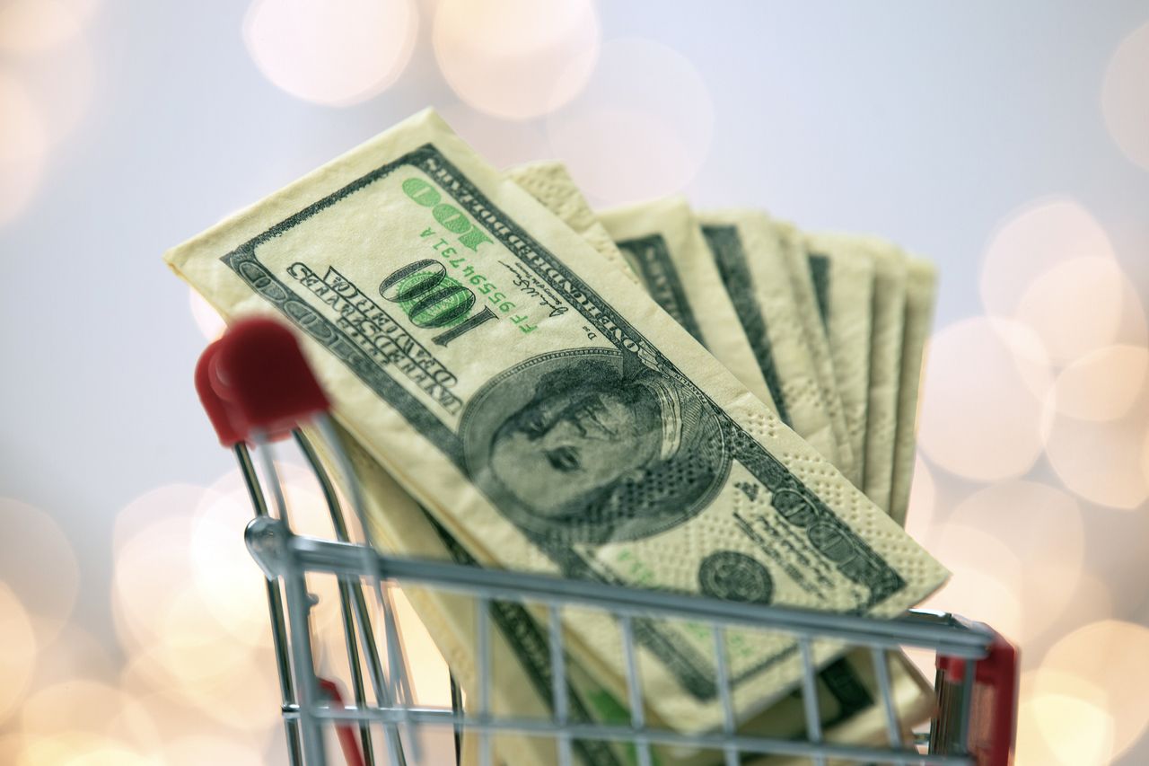 image of a shopping cart full of one hundred dollar bills