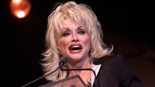 Dolly Parton accepting her Johnny Mercer Award at the Songwriters Hall of Fame 32nd Annual Awards in New York City, 2001. That year, she performed “The Last Thing On My Mind” with Doc Watson at MerleFest.