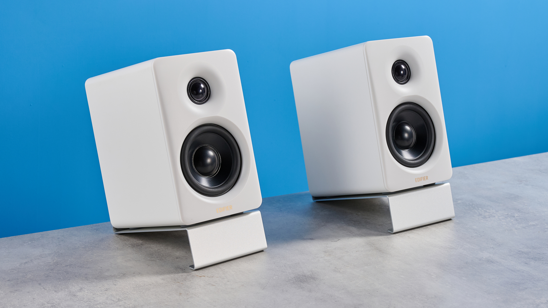 the edifier m60 bookshelf speakers in white photographed against the blue tom's guide background