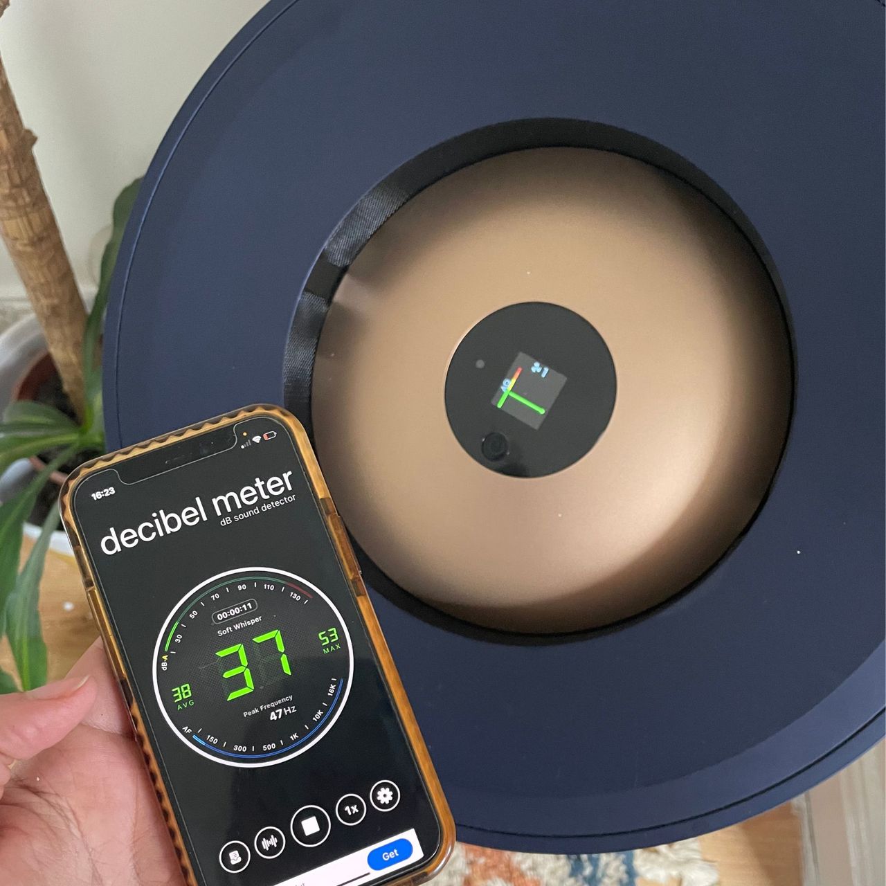 hand holding a phone with a decibel meter app in front of the Dyson Big+Quiet air purifier