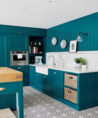 teal painted kitchen with marble countertop