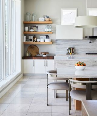Modern kitchen with kitchen island, wooden shelving, dining table with seating