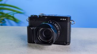 Fujifilm X-E4 on a stone surface and blue background