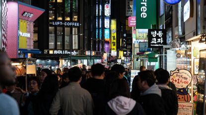 A bustling street at night in Seoul, South Korea.