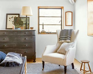 bedroom with gray chest of drawers and high back armchair