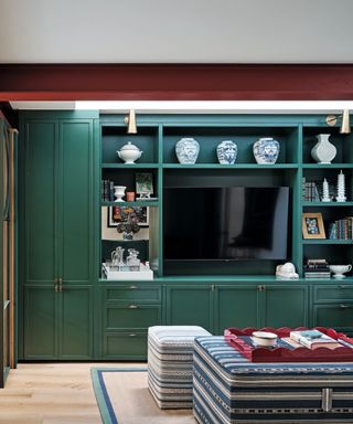 green cabinets in living area with ottoman and tv