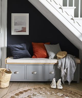 Shoe storage idea in the hallway with a bench under the stairs