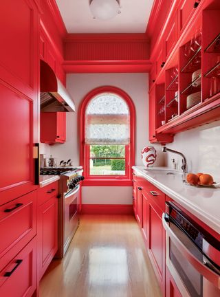 Red kitchen with white countertops and red cabinets