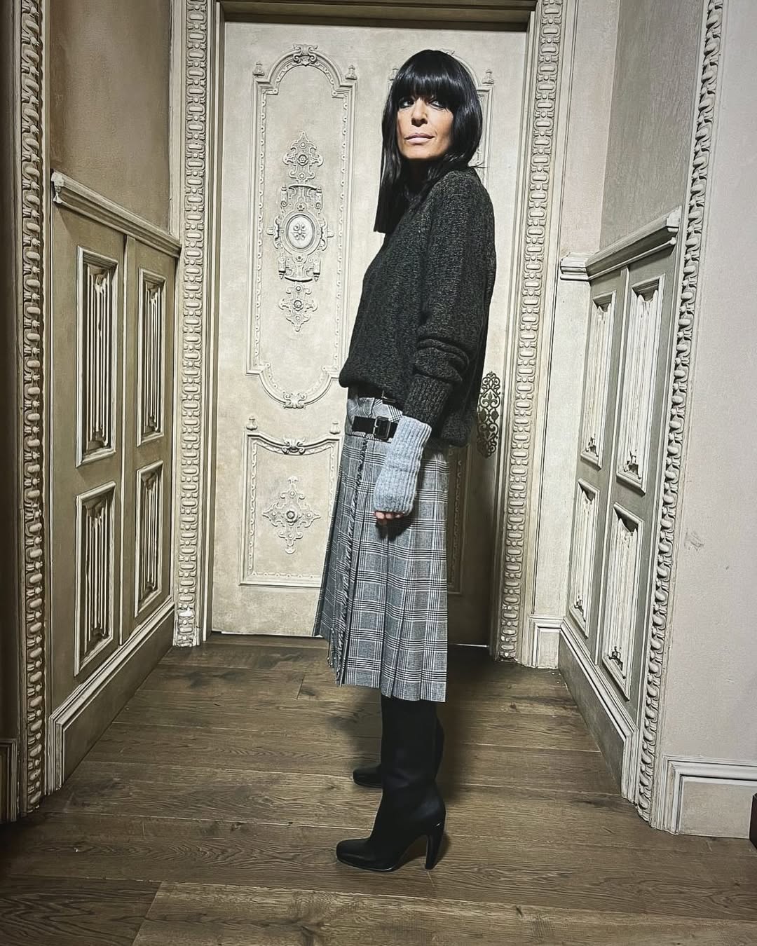 Claudia Winkleman wearing grey knit and kilt skirt
