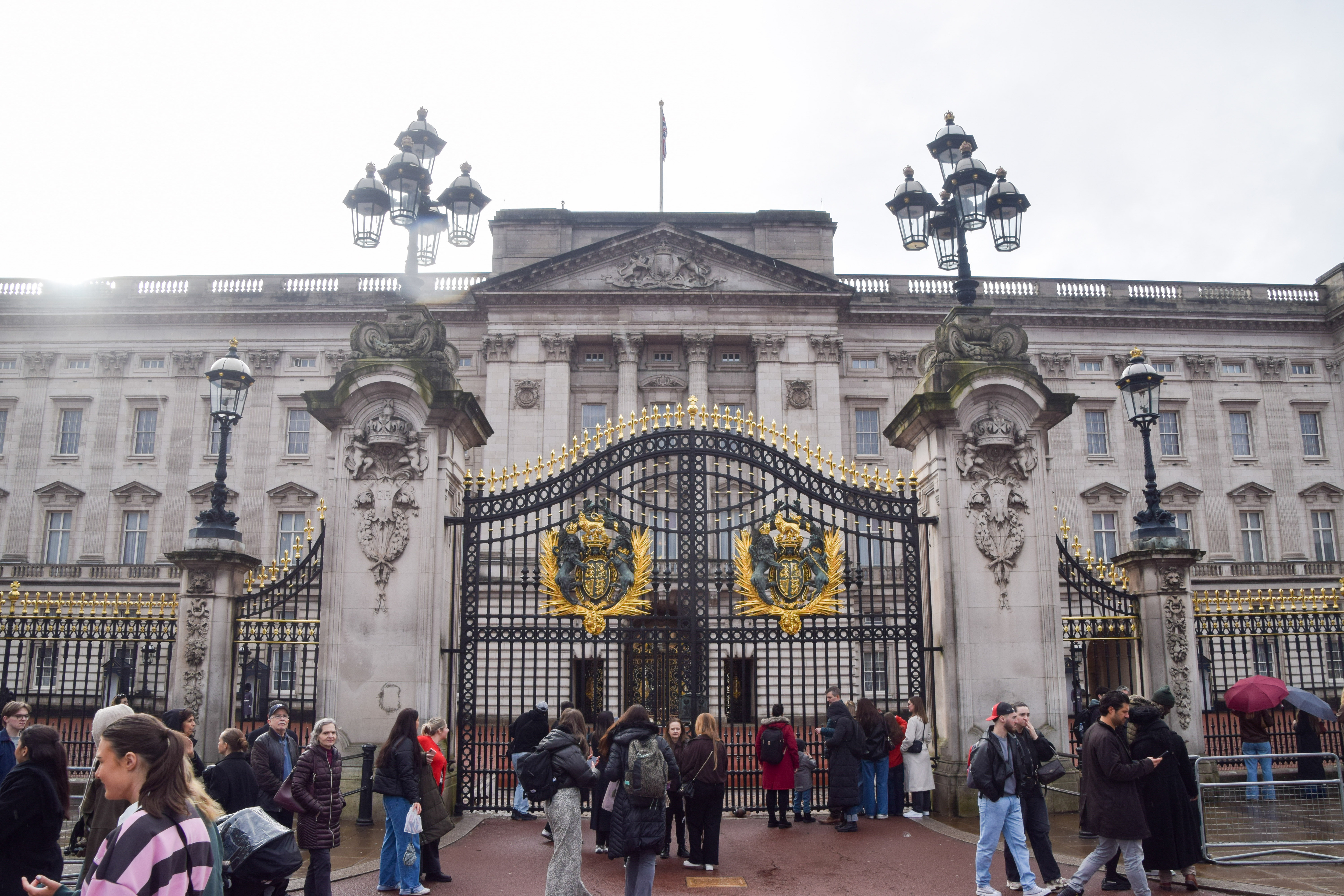 The exterior of Buckingham Palace with tourists in front