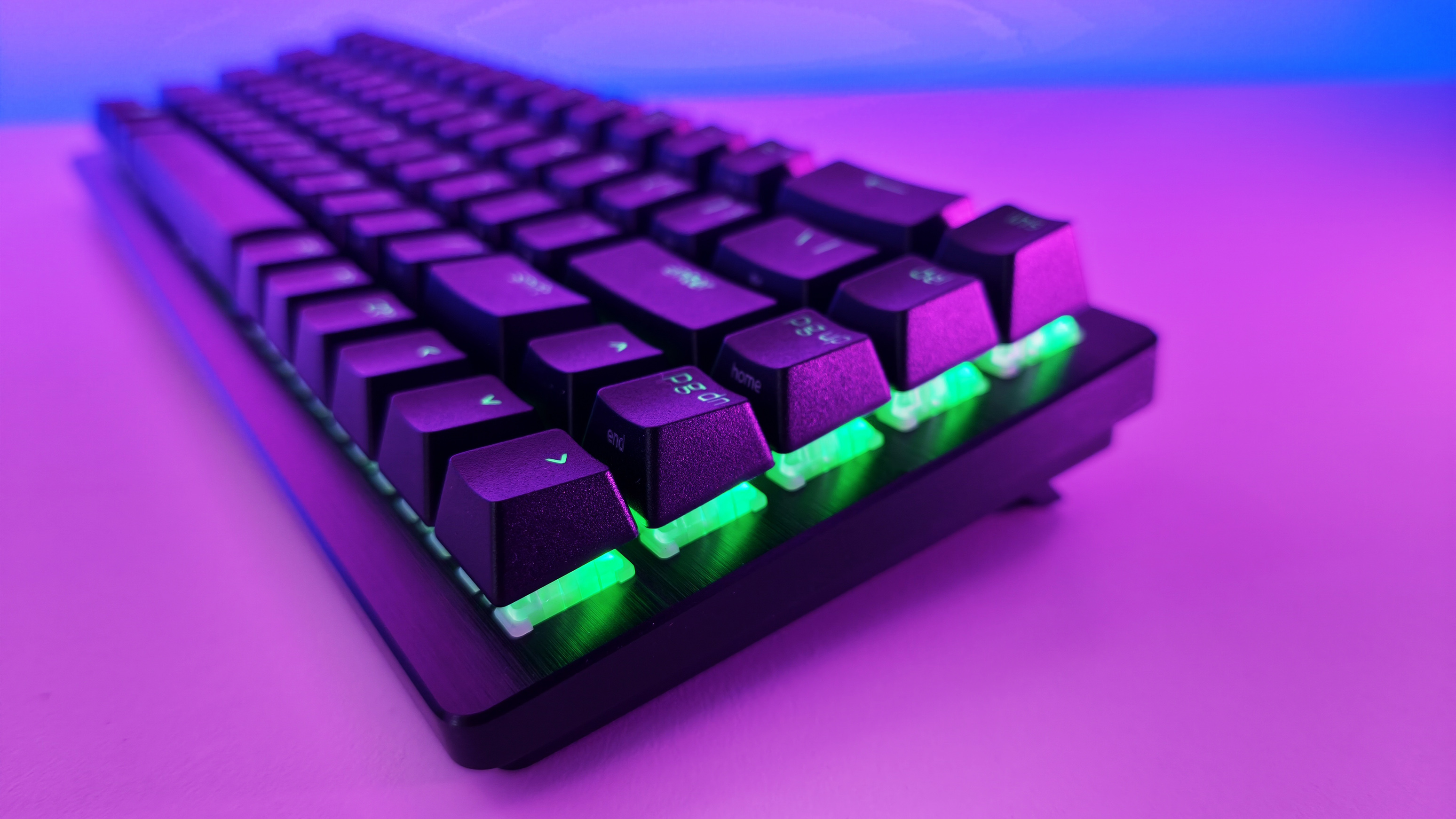 Angled side view of a black Razer gaming keyboard featuring green RGB backlighting glowing beneath floating keycaps.