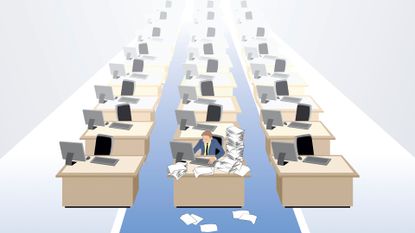 Talent shortage concept image showing lone worker with files piled up on desk with rows of empty desks in an open plan office space.