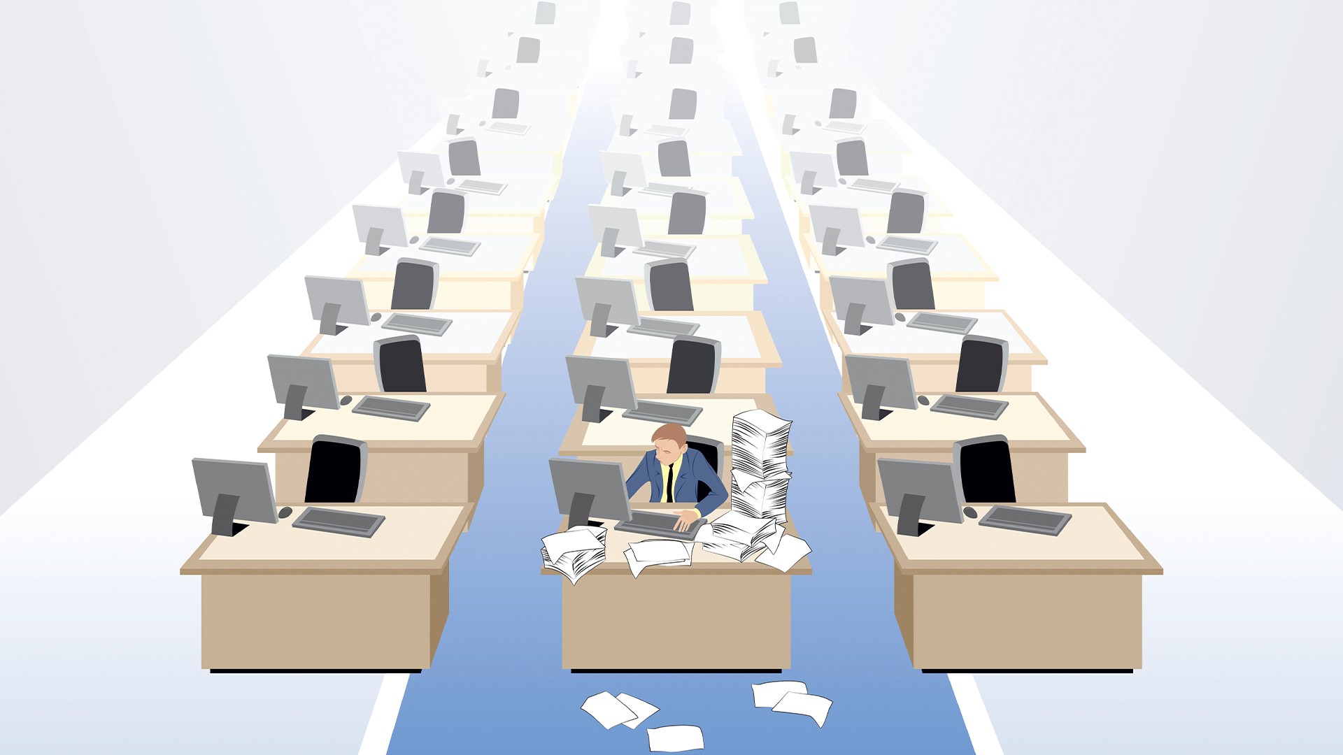 Talent shortage concept image showing lone worker with files piled up on desk with rows of empty desks in an open plan office space.
