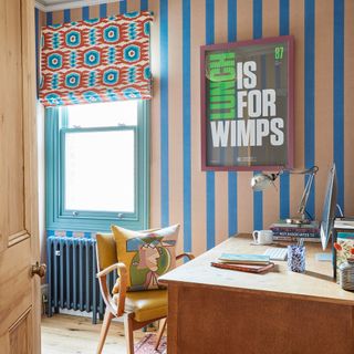 home office with striped wallpaper patterned Roman blinds and a large framed print