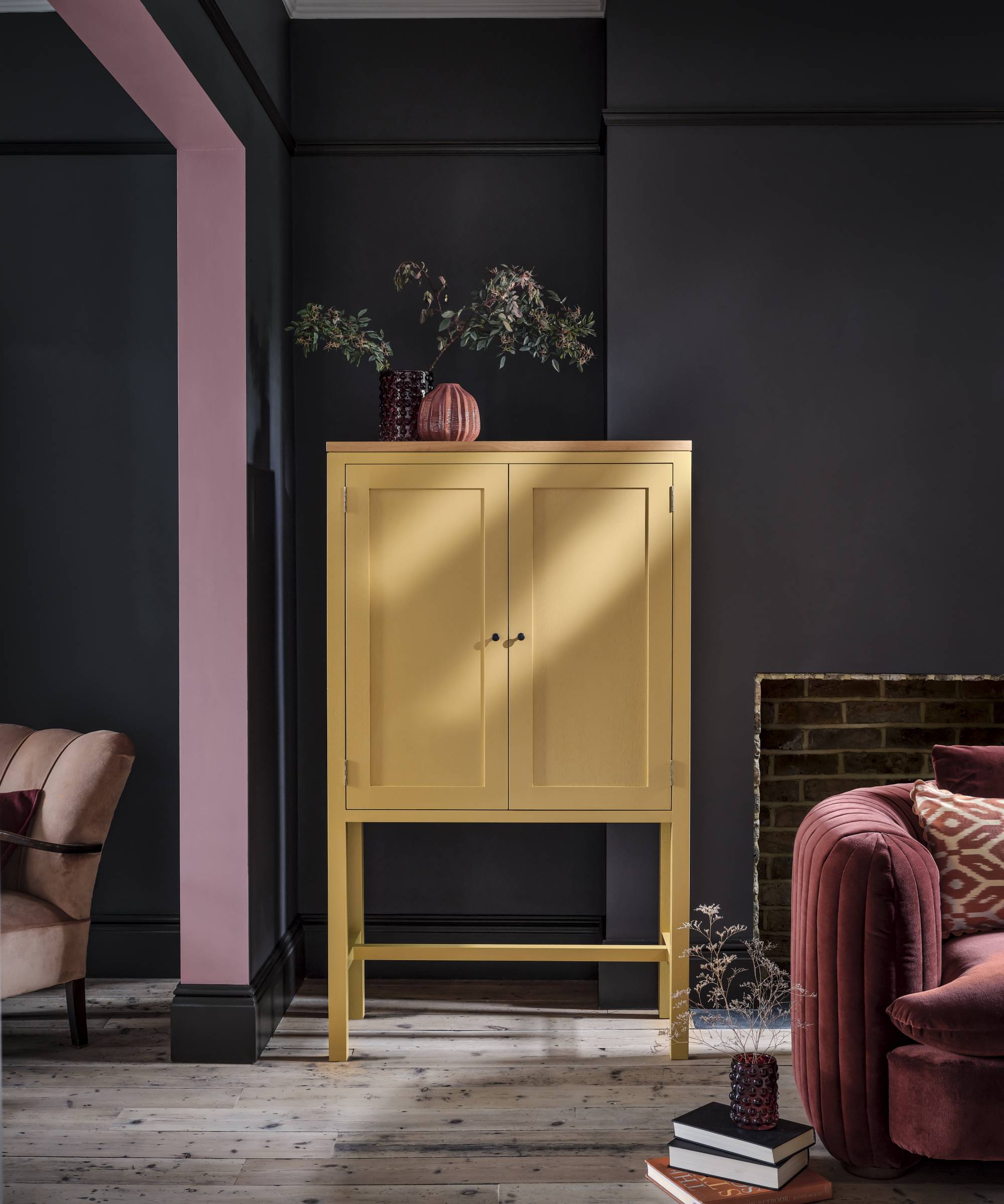 open plan living area painted in grey with archway between spaces painted pink