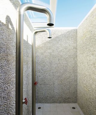 Outdoor bathroom with huge showers in tiled cubicle