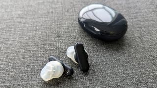 Ultimate Ears UE Fits review: true wireless earbuds next to matching charging case