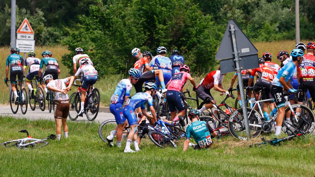 Overall leader Team Ineos Ecuadorian rider Richard Carapaz CR and other riders go to pick their bicycle after a crash in the first kilometers of the 15th stage of the Giro dItalia 2022 cycling race 177 kilometers from Rivarolo Canavese Piedmont to Cogne Aosta Valley on May 22 2022 Photo by Luca Bettini AFP Photo by LUCA BETTINIAFP via Getty Images