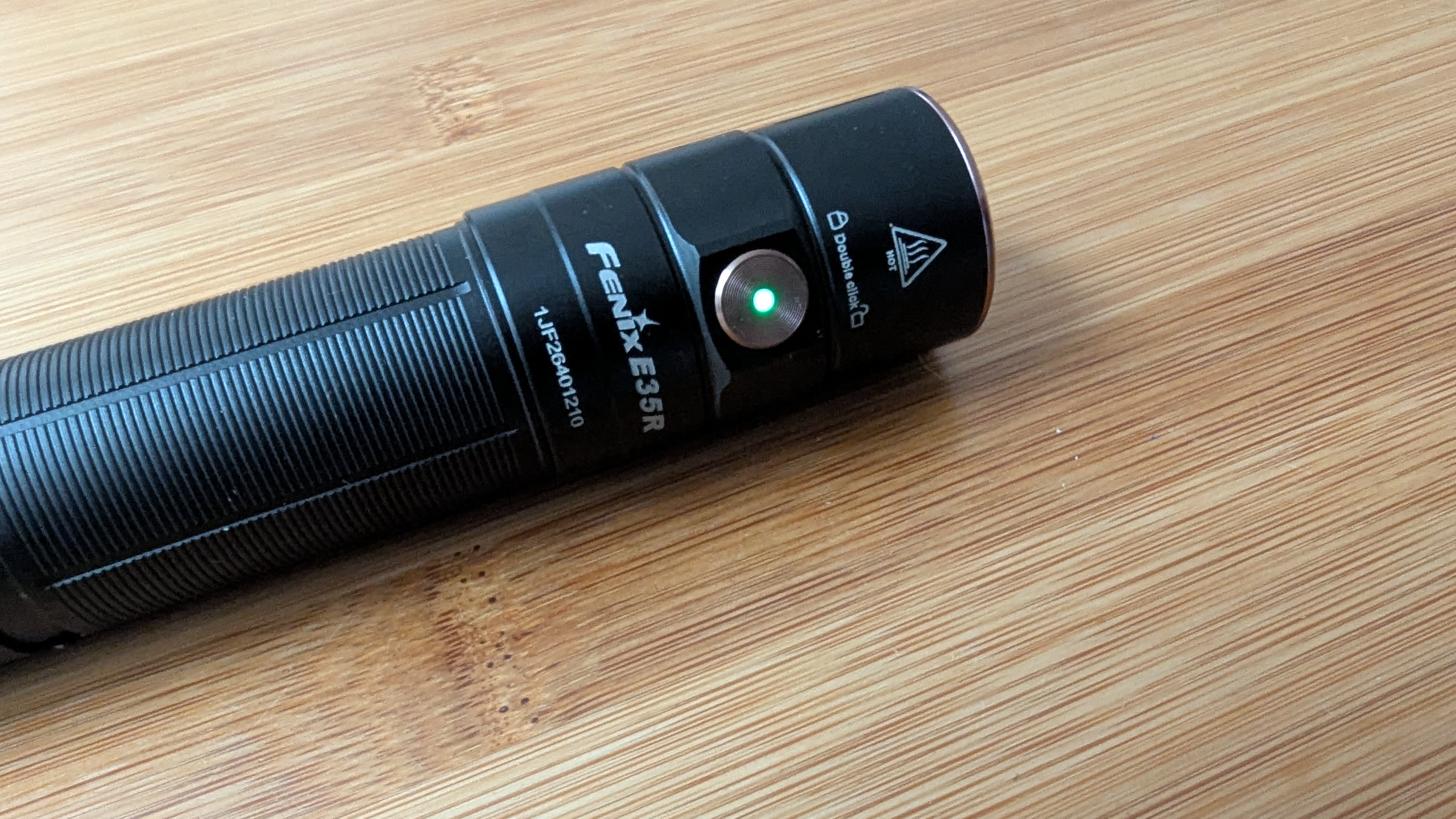 Fenix E35R flashlight with the green battery indicator light showing