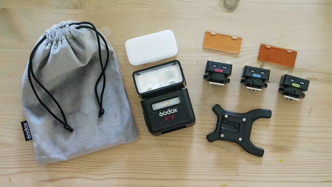 Flat lay of the Godox iT32 camera flash kit on a wooden table