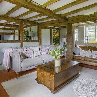 living room with wooden ceiling beams and sofa set