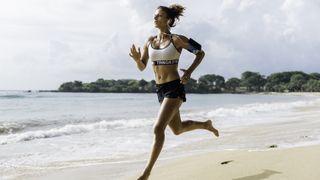 A woman running along the shoreline