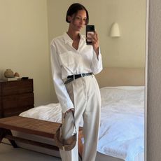 A woman wearing a white button-down and khaki pants