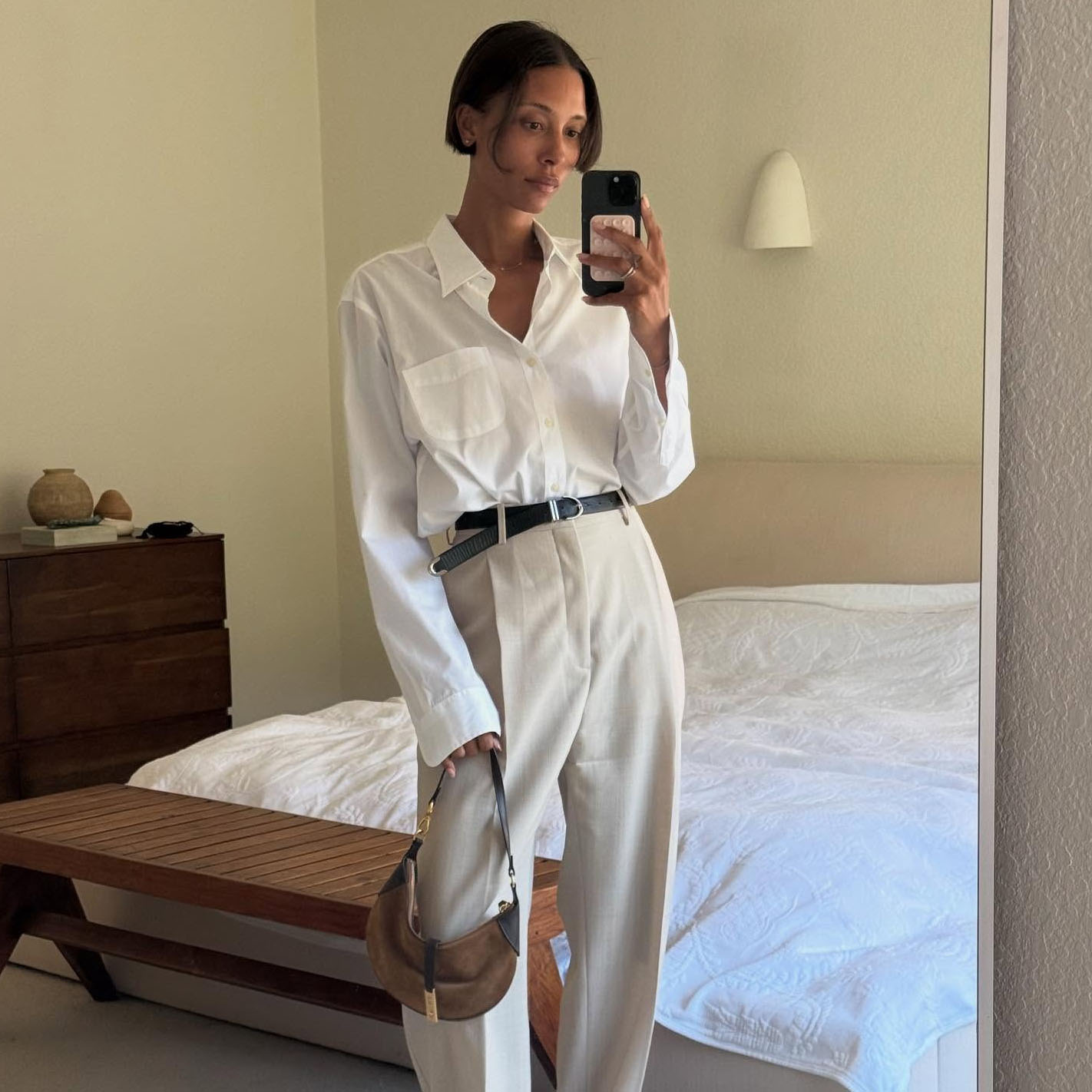 A woman wearing a white button-down and khaki pants