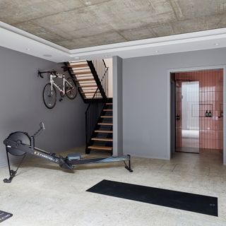 Grey gym with yoga mat and rowing machine