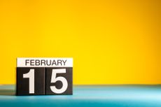 February 15 blocks on a blue surface against a yellow background