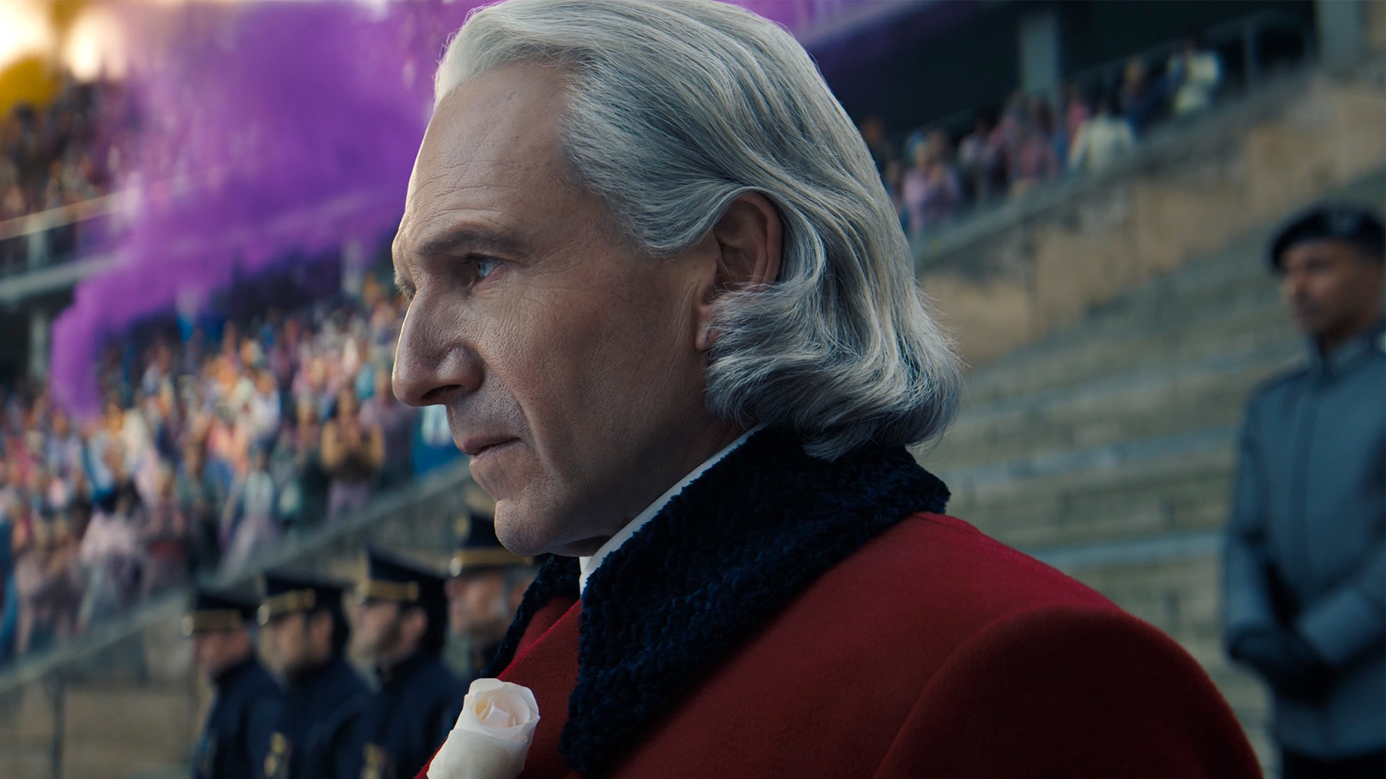 Ralph Fiennes with long grey hair and wearing a red coat in Sunrise on the Reaping
