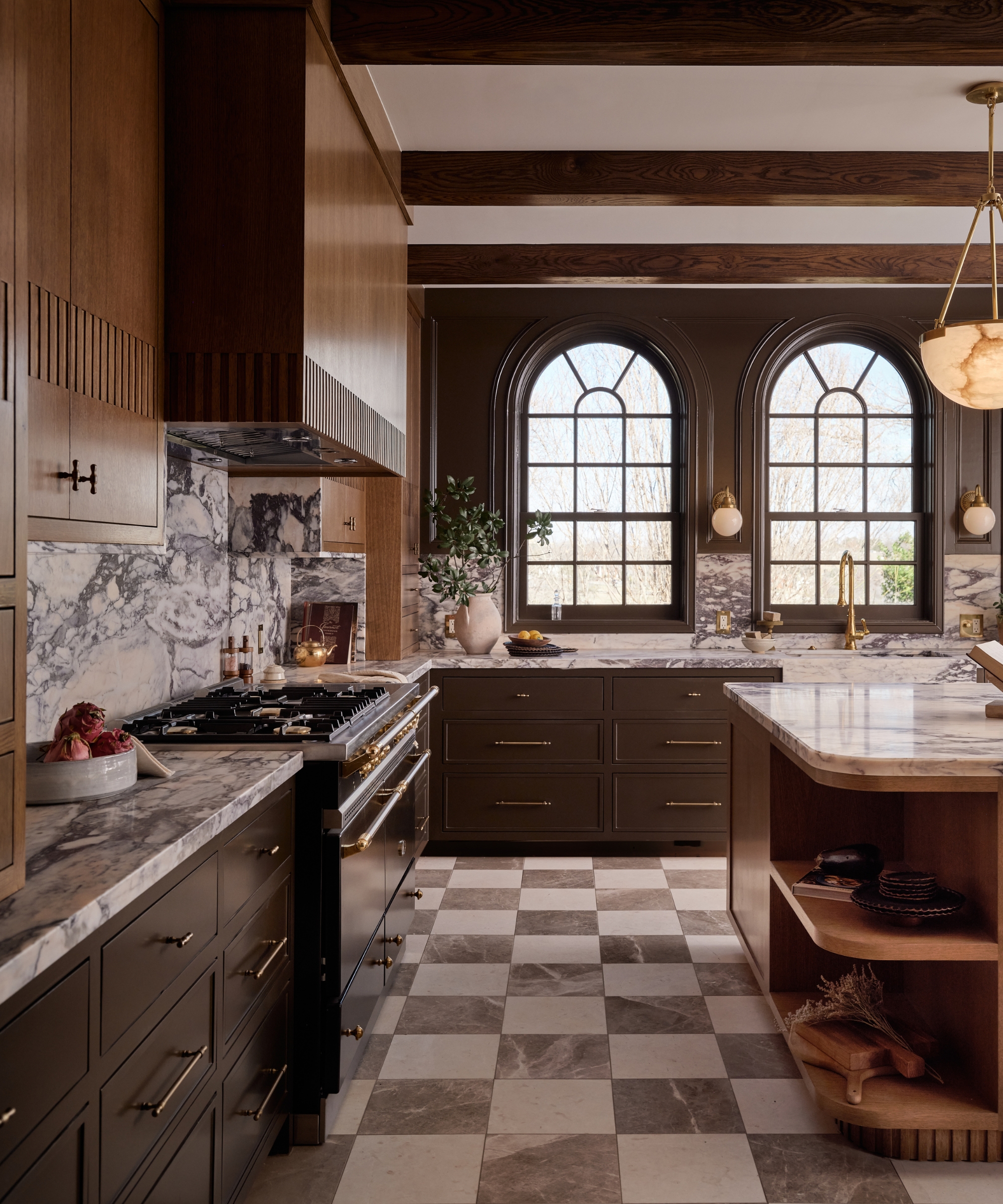 A wooden kitchen with arched windows and a checkerboard floor