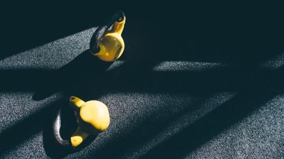 Two kettlebells lying on floor for farmer's carry exercise