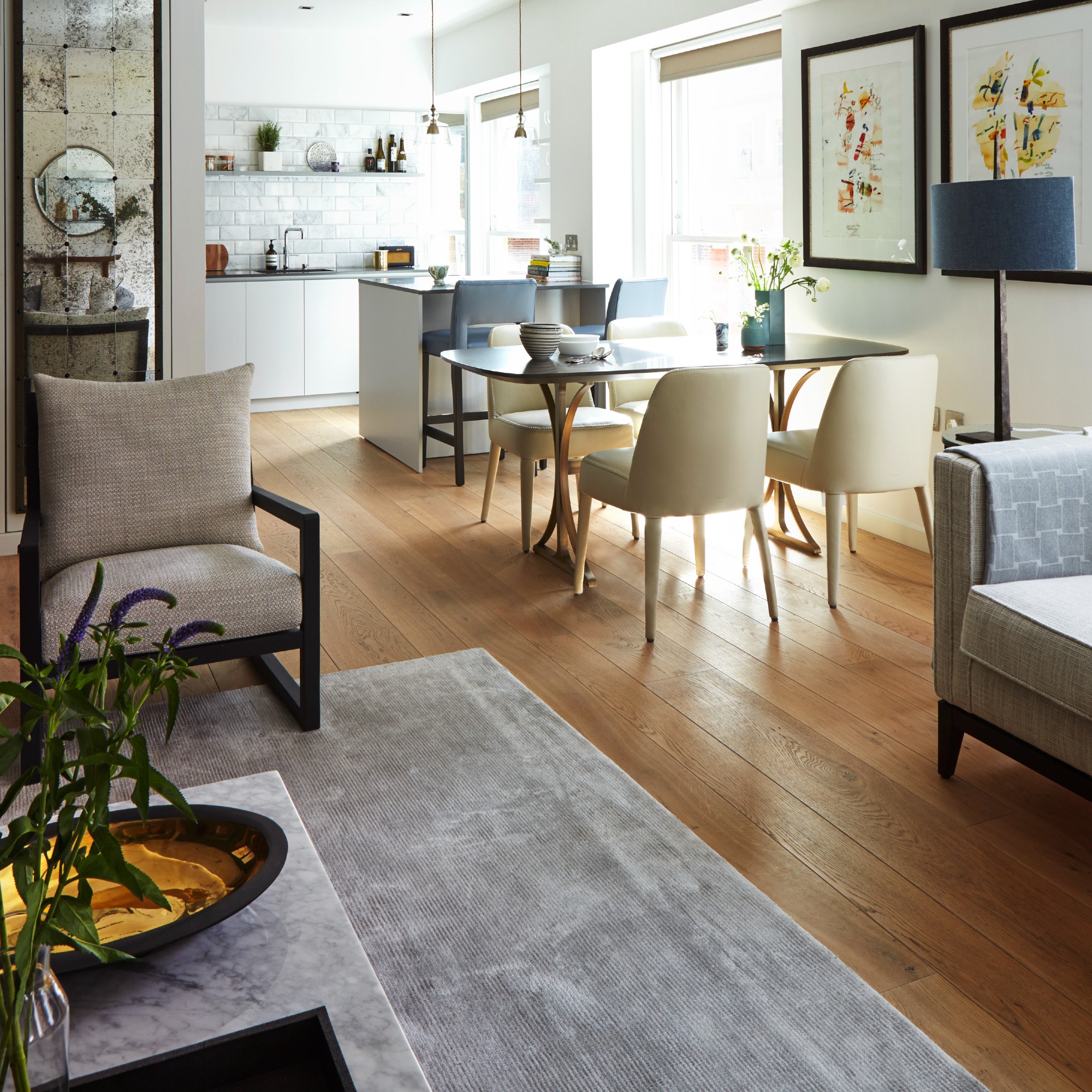 An open-plan living room with a grey rug used for zoning the space