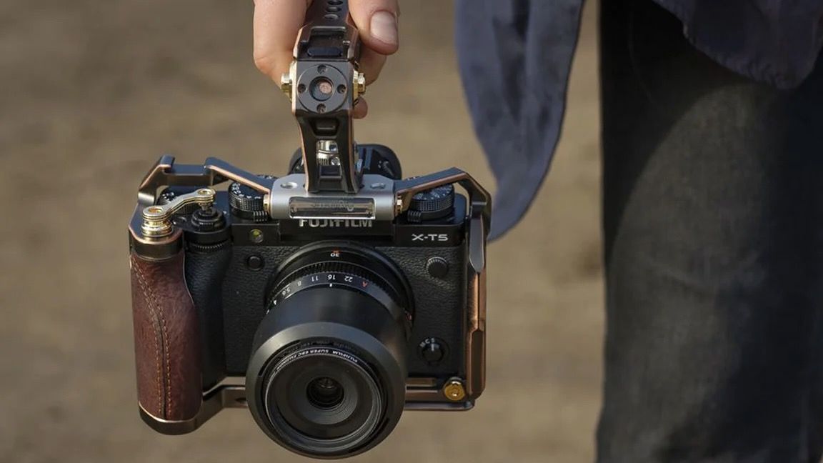 A person holding a Fujifilm X-T5 in a SmallRig cage