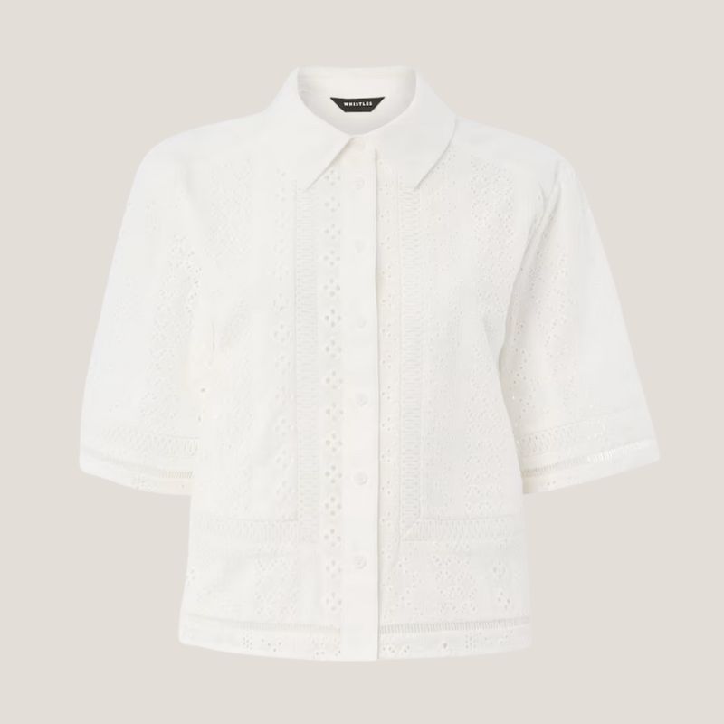 A cut out of a Whistles embroidered blouse on a pale background