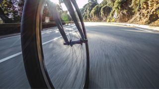 Low view of bike wheels going down an open road