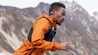 Man running in mountains wearing Shokz OpenSwim Pro headphones