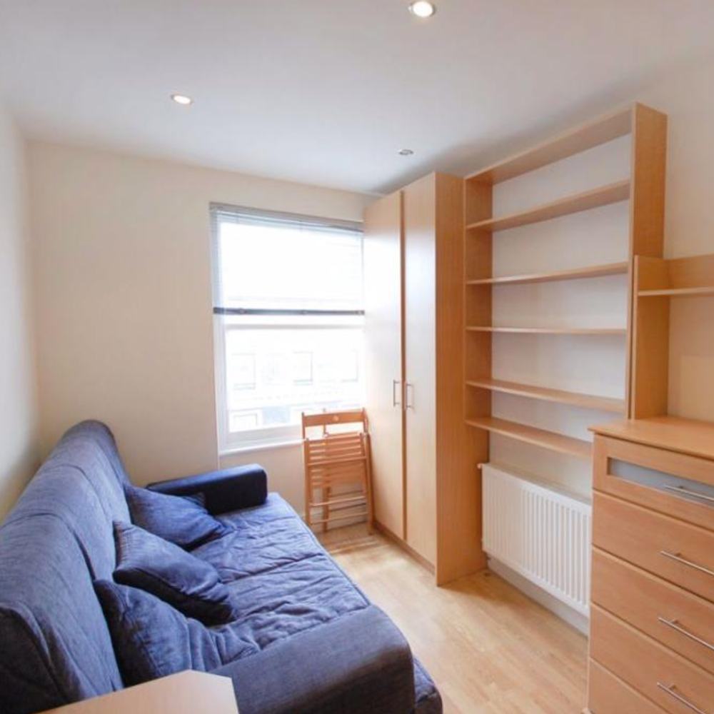white wall with shelf and sofa with cushions