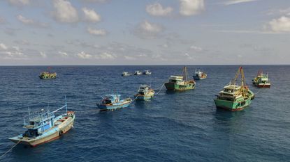 fishing boats joined up on the open ocean