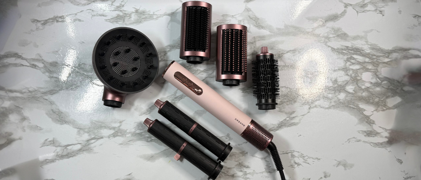 Dreame AirStyle Era multi-styler with the attachments including diffuser, styling brushes, barrels and straightening nozzle laid out on a makeup table
