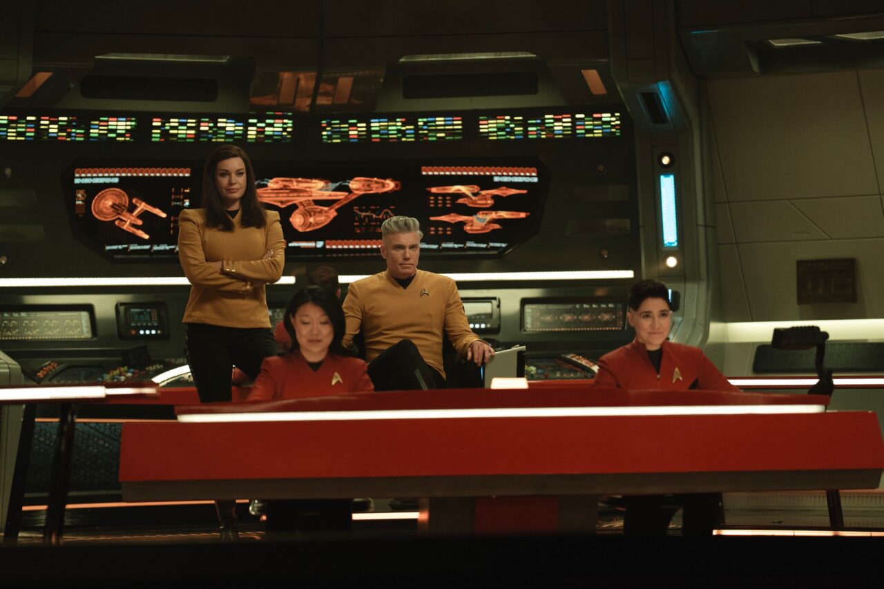 four crew members on the bridge of a sci-fi starship