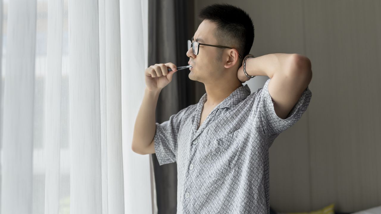 Man exercising while brushing his teeth